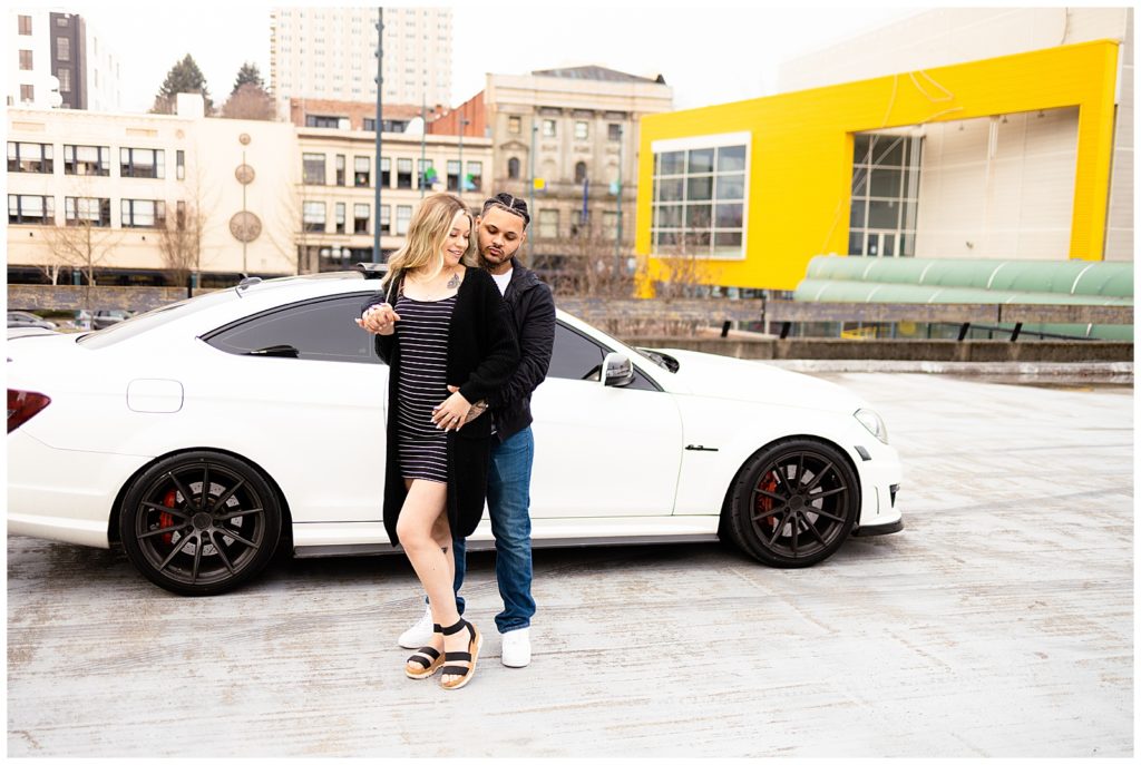 baby bump photo in front of sports car