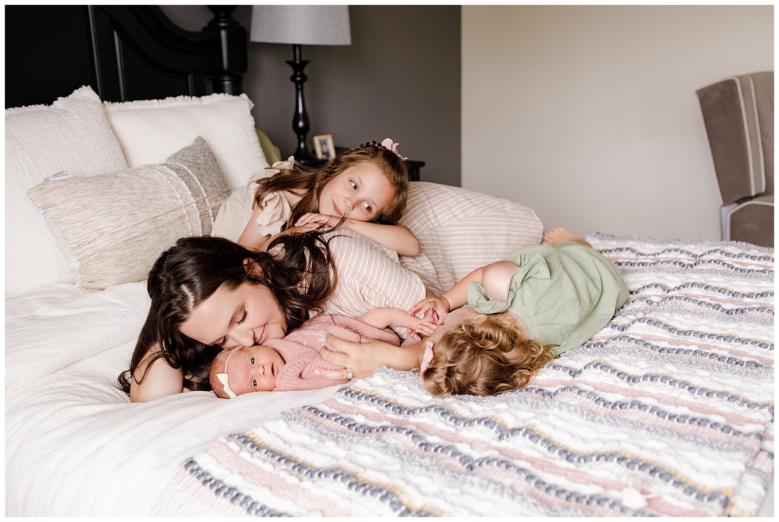 tacoma mom with her three rainbow babies cuddling on her bed during a newborn photo session