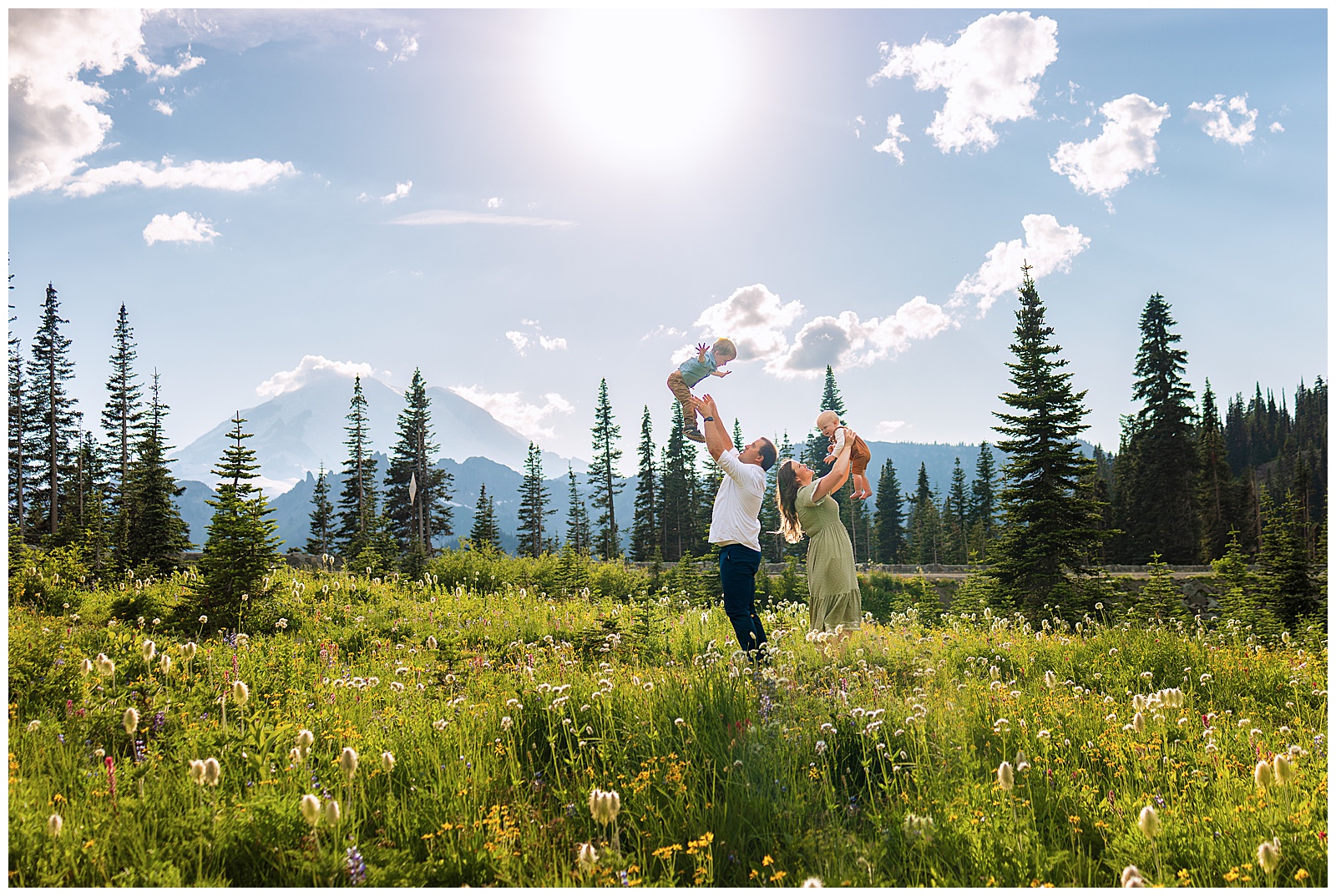 family of four getting family photos taken with mt rainier in the background